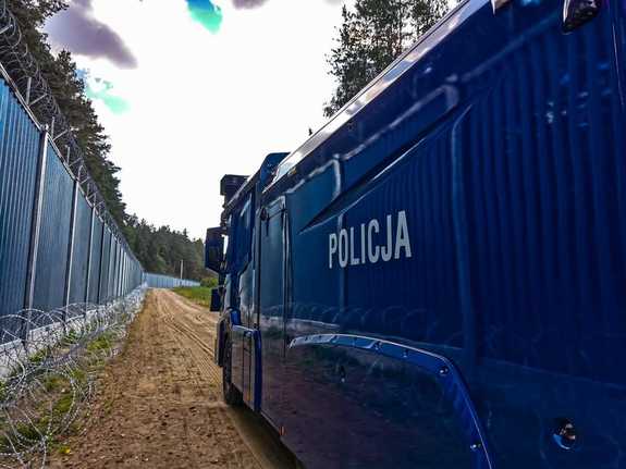 policjanci stoją przy granicy polsko-białorusiej , radiowóz