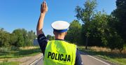policjant ruchu drogowego z ręką podniesioną zatrzymuje do kontroli