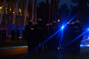 policjanci w białych kaskach stoją przy stadionie