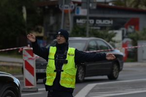 Policjanci ruchu drogowego wykonujący czynności służbowe oraz zdjęcie radiowozu
