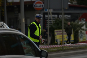 Policjanci ruchu drogowego wykonujący czynności służbowe oraz zdjęcie radiowozu