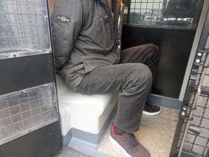 mężczyzna siedzi w pojeździe dla zatrzymanych