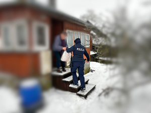 policjant z kobietą na schodach domu