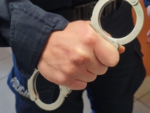 policjant trzyma kajdanki