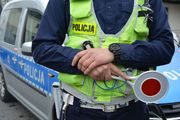 sylwetka policjanta trzymającego lizak policyjny do kierowania ruchem