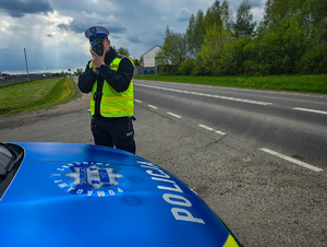 policjant z urządzeniem do mierzenia prędkości przy twarzy