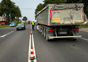 policjant kontrolujący ciężarówkę na jezdni