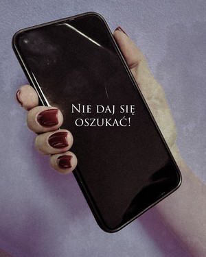 ekran telefonu trzymany w dłoni, na ekranie napis nie daj się oszukać