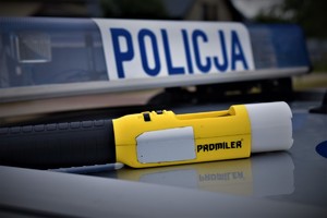 na dachu radiowozu widać uprzywilejowane światła na nim zamontowane oraz napis policja oraz urządzenie do mierzenia zawartości alkoholu w organizmie