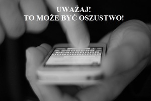 napis uważaj to może być oszustwo oraz widok rąk z aparatem telefonicznym