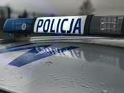 dach radiowozu policyjnego z zamontowanymi na nim światłami uprzywilejowanymi i napisem policja