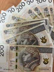 rozłożony na stoliku plik banknotów po 200 złotych