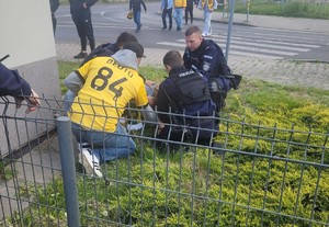 policjanci udzielający leżącej na ziemi kobiecie