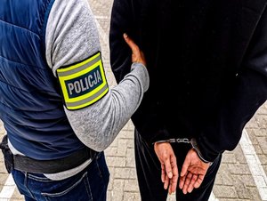 policjant prowadzi zatrzymanego
