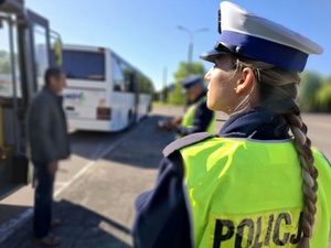 policjant i policjantka kontrolują autokar przewożący dzieci