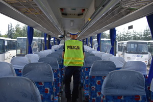 policjant stojący tyłem w autokarze