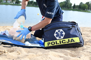 policjant przy fantomie do nauki udzielania pomocy