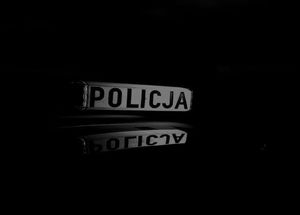 czarne tło a na nim białe tło i napis czarny policja