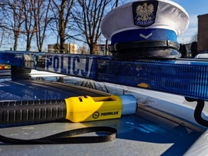 na dachu radiowozu leżąca czapka policjanta oraz urządzenie do mierzenia trzeźwości