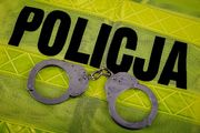 kajdanki na odblaskowej kamizelce z napisem policja