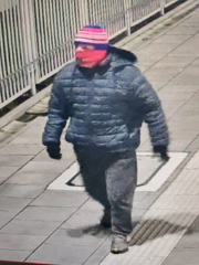 osoba idąca ulicą z zamaskowaną twarzą