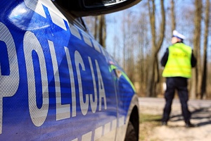 radiowóz i policjant w tle