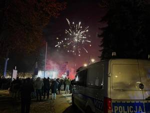 policjanci w tle budynki i fajerwerki