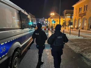 policjanci w tle budynki i fajerwerki
