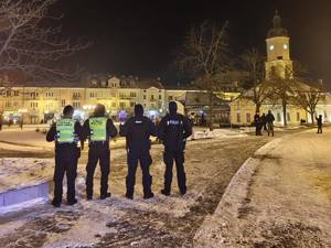 policjanci w tle budynki i fajerwerki