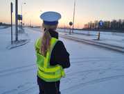 policjantka ruchu drogowego stojąca tyłem przy jezdni