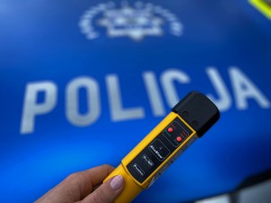 na niebieskim tle napis policja i urządzenie do mierzenia zawartości alkoholu w organizmie