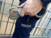 policjant ma w ręku kajdanki