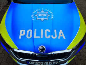 maska radiowozu, na niebieskim tle napis policja pomagamy i chronimy