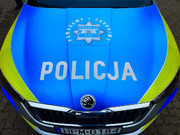 maska radiowozu, na niebieskim tle napis policja pomagamy i chronimy