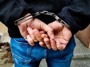 ręce osoby w kajdankach zapiętych na nadgarstkach z tyłu