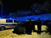 policjanci stoją przy pojeździe jest noc