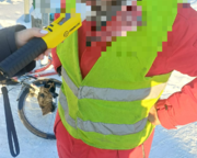 policjant z urządzeniem do badania trzeźwości i mężczyzna w kamizelce odblaskowej