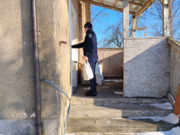 POLICJANT STOI PRZED DRZWIAMI BUDYNKU