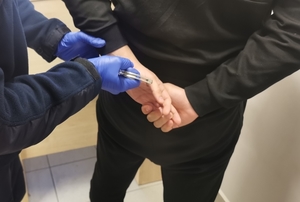 policjant zakłada kajdanki na ręce mężczyzny