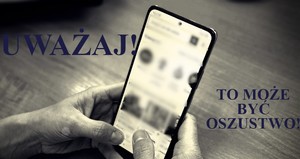 napis uważaj to może być oszustwo w tle telefon w dłoniach
