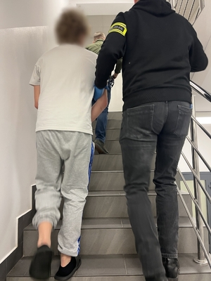 policjanci prowadzą osobę zatrzymaną