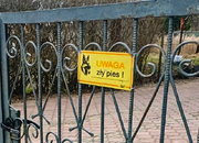 ogrodzenie a na nim tabliczka z napisem uwaga zły pies