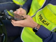 dłonie policjanta i urządzenie do sprawdzania danych