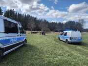 pojazdy policji i motorower nad rzeką