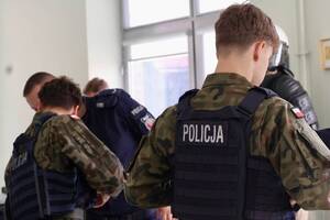 uczniowie przy stoiskach promocyjnych policji